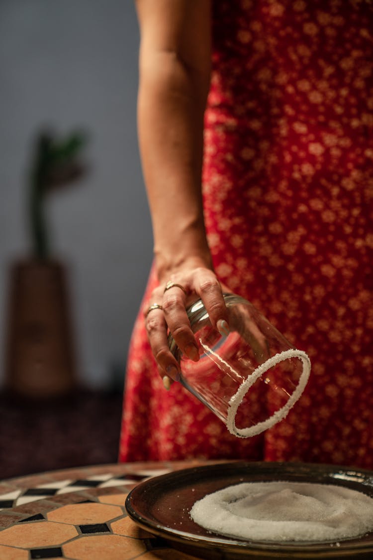 Woman Coating Rim Of Glass With Salt