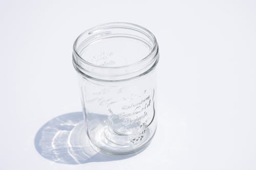 Close-Up Photo of an Empty Glass Jar on a White Surface