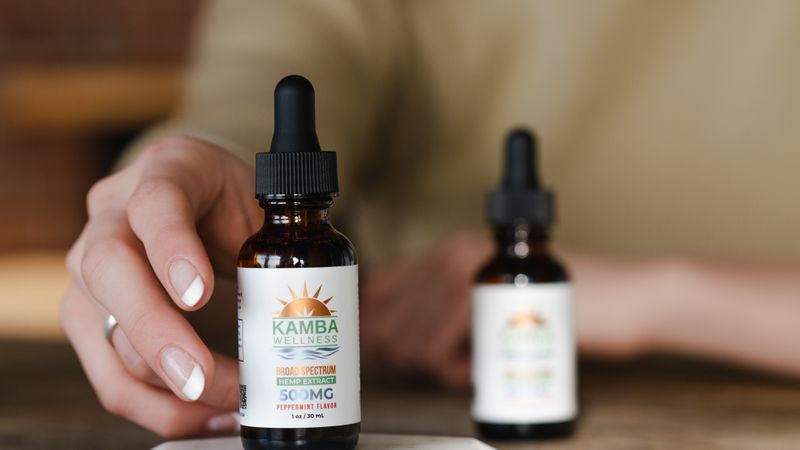 Hand reaching for a CBD oil dropper bottle, illustrating CBD and antidepressants decisions