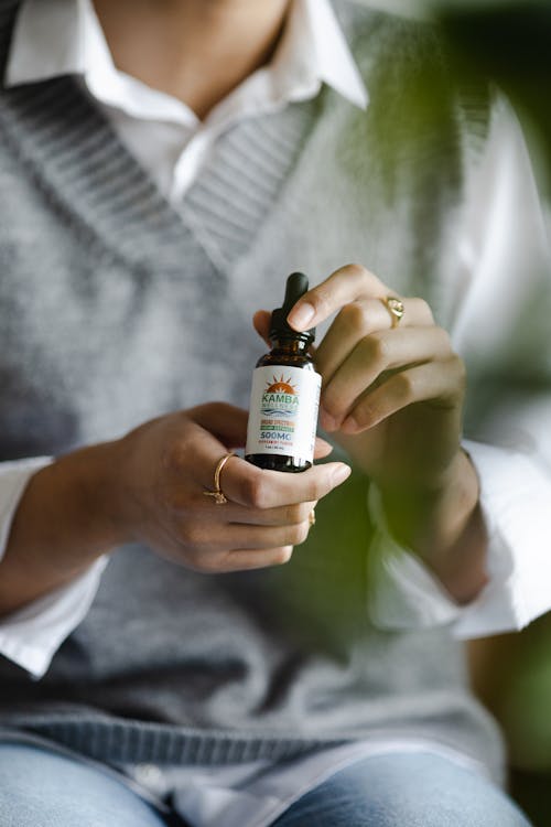 A Woman Holding a Bottle of CBD Oil

