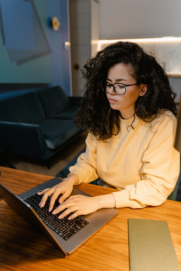 Woman In Yellow Sweater Using A Laptop 