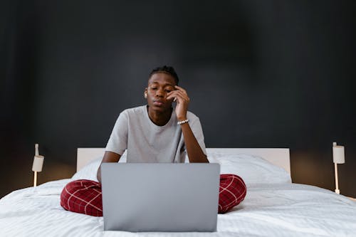 A Man Using a Laptop while in Bed