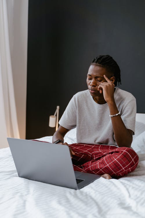 Man Using a Laptop on the Bed