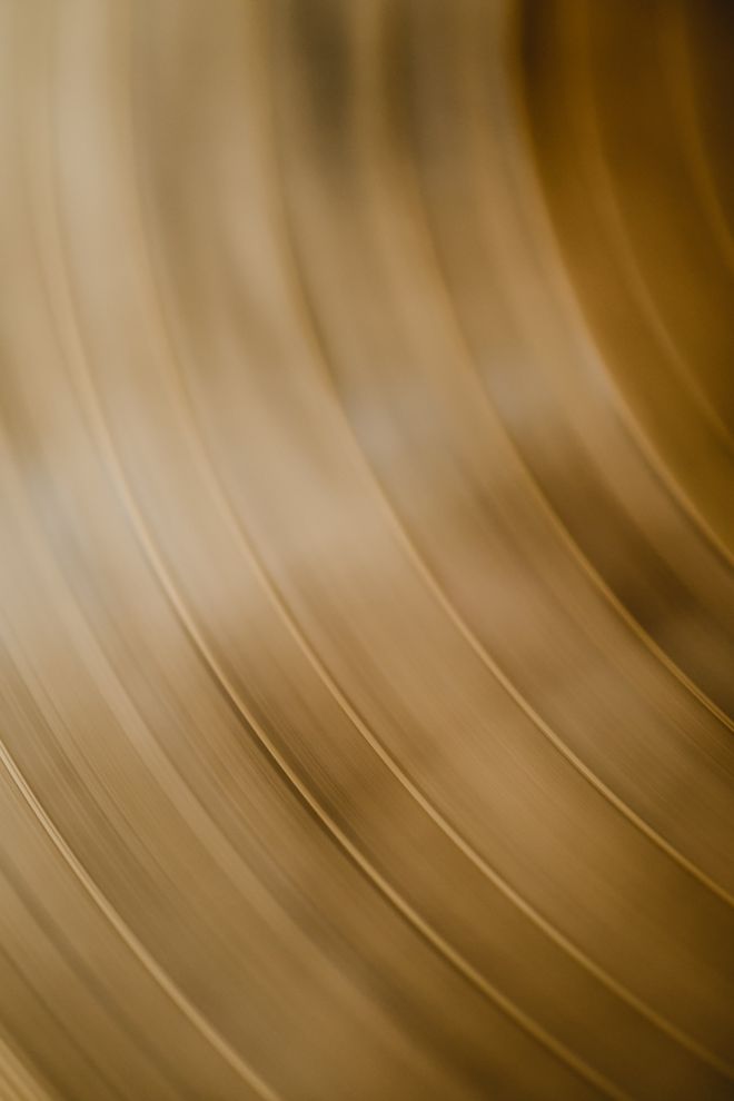Blurred close-up of a warm brass surface. Photo by Eva Bronzini on Pexels.