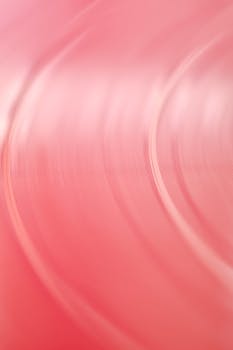 Artistic abstract motion blur of a pink vinyl record creating soothing curves and textures.