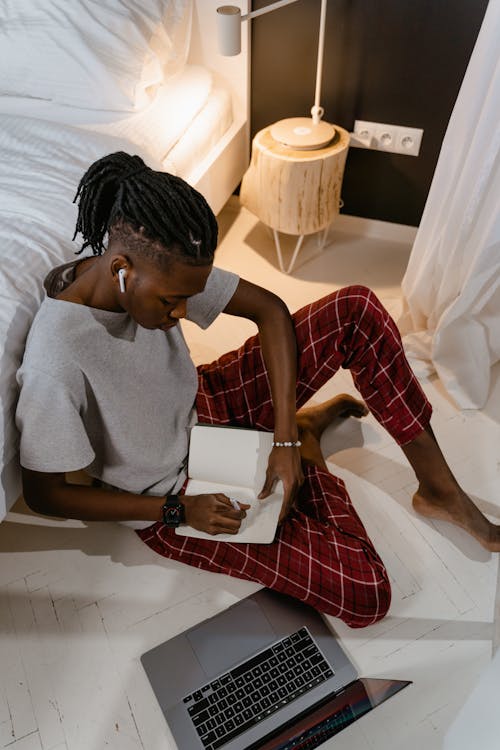 Free Man Sitting on Floor Writing Stock Photo