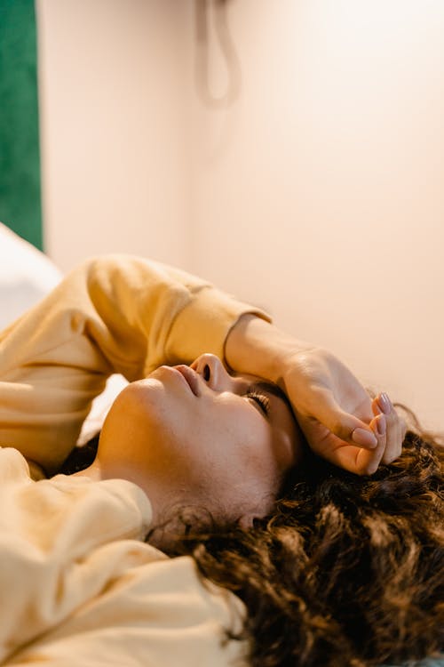 Man in Yellow Shirt Lying on Bed