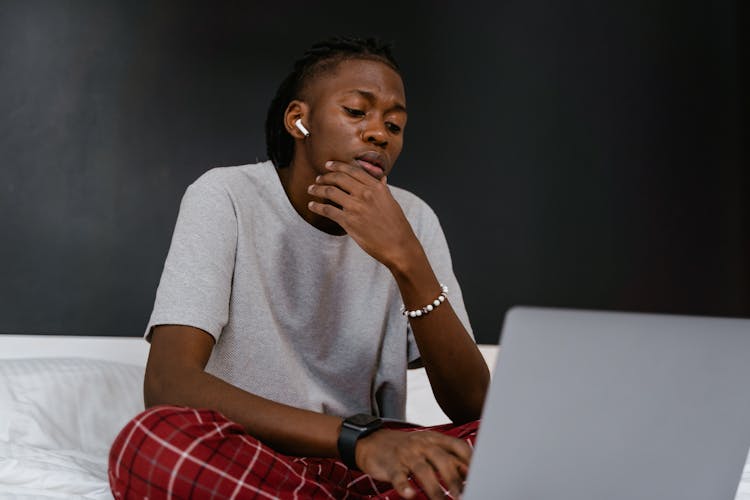 A Man With Airpods Using A Laptop