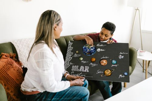 Free Mother and son working on a solar system project. Engaging family time indoors. Stock Photo