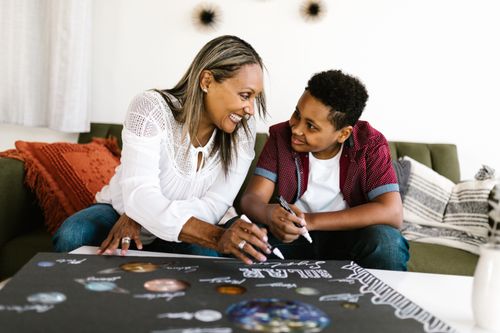 Free Mother and son smiling as they work together on an art project indoors. Stock Photo