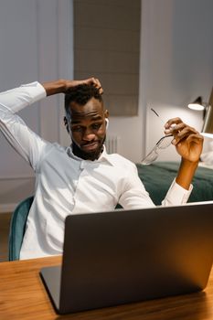 Man in a home office working on a laptop, reflecting remote work lifestyle.
