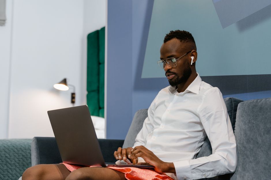 Man sitting on a sofa working remotely on a laptop at home. Man sitting on a sofa working remotely on a laptop at home.