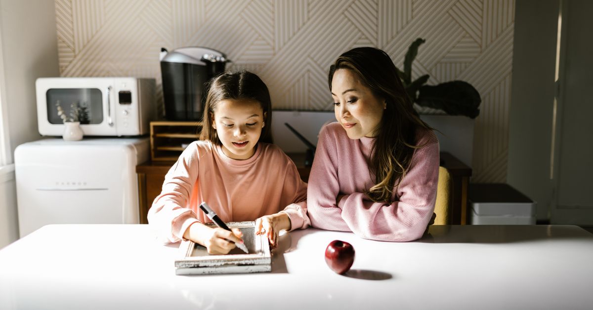 diverse family doing homework together at kitchen table