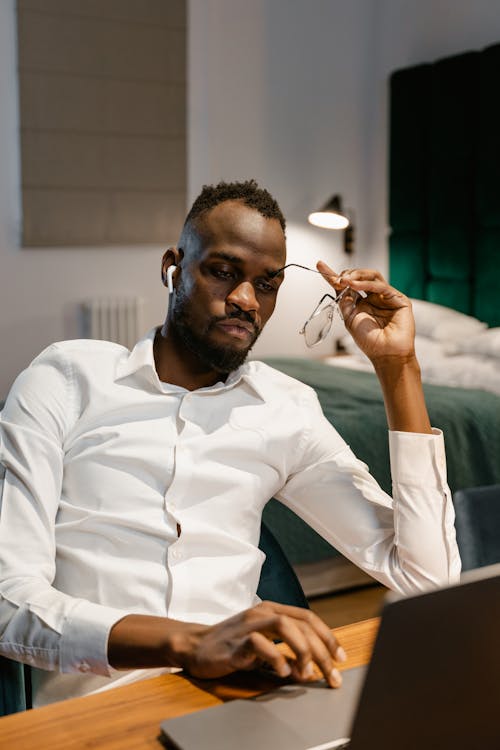 A Man Thinking While Using Laptop