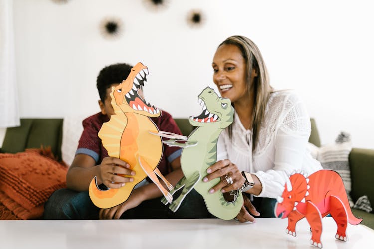 A Mother And Son Playing With Dinosaurs