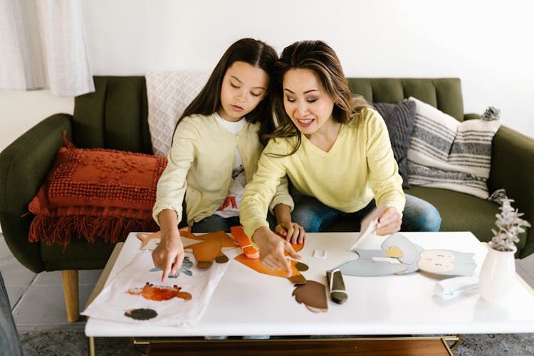 A Mother And Daughter Doing A School Project Together At Home