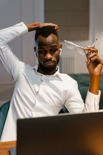 Focused man working remotely from home, contemplating while on laptop. - The Impact of LaTeX-Generated CVs on Standard Commercial ATS Parsers