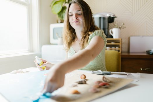 Teen girl enjoying a relaxing indoor crafting activity with focus on creativity and enjoyment.