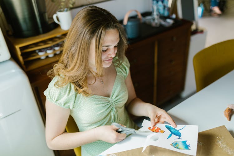 A Woman Cutting Paper With Pictures