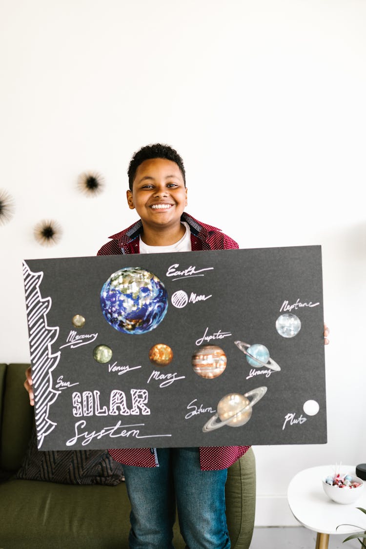 A Boy Holding A School Project