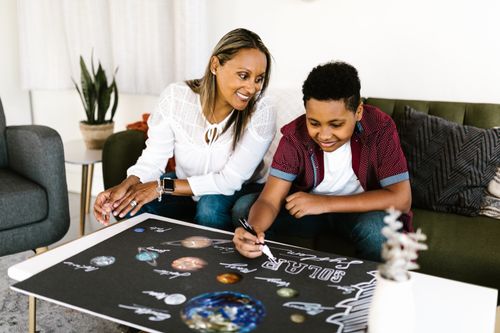 Free Mother and son engaging in a creative school project about the solar system at home. Stock Photo