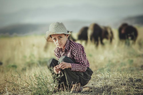 A Boy Crouching in a Field