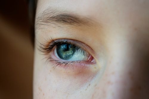 Free Closeup face of unrecognizable boy with freckles and blue eyes looking away with concentration while standing on blurred background Stock Photo