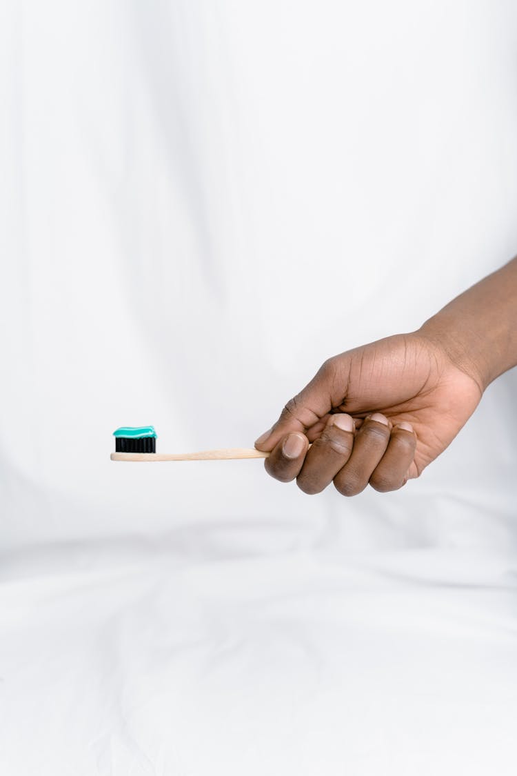 Person Holding A Toothbrush With Toothpaste