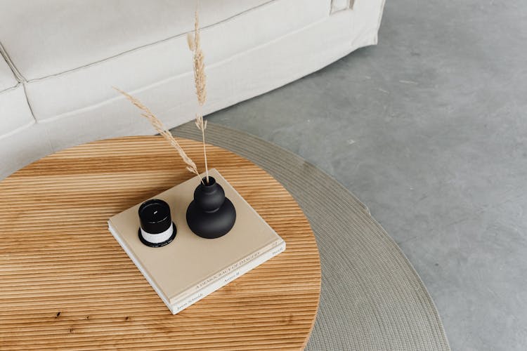 Vase And Wax Candle On Books On Table