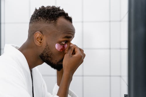 Free A Side View of a Man Putting an Under Eye Mask on His Face Stock Photo