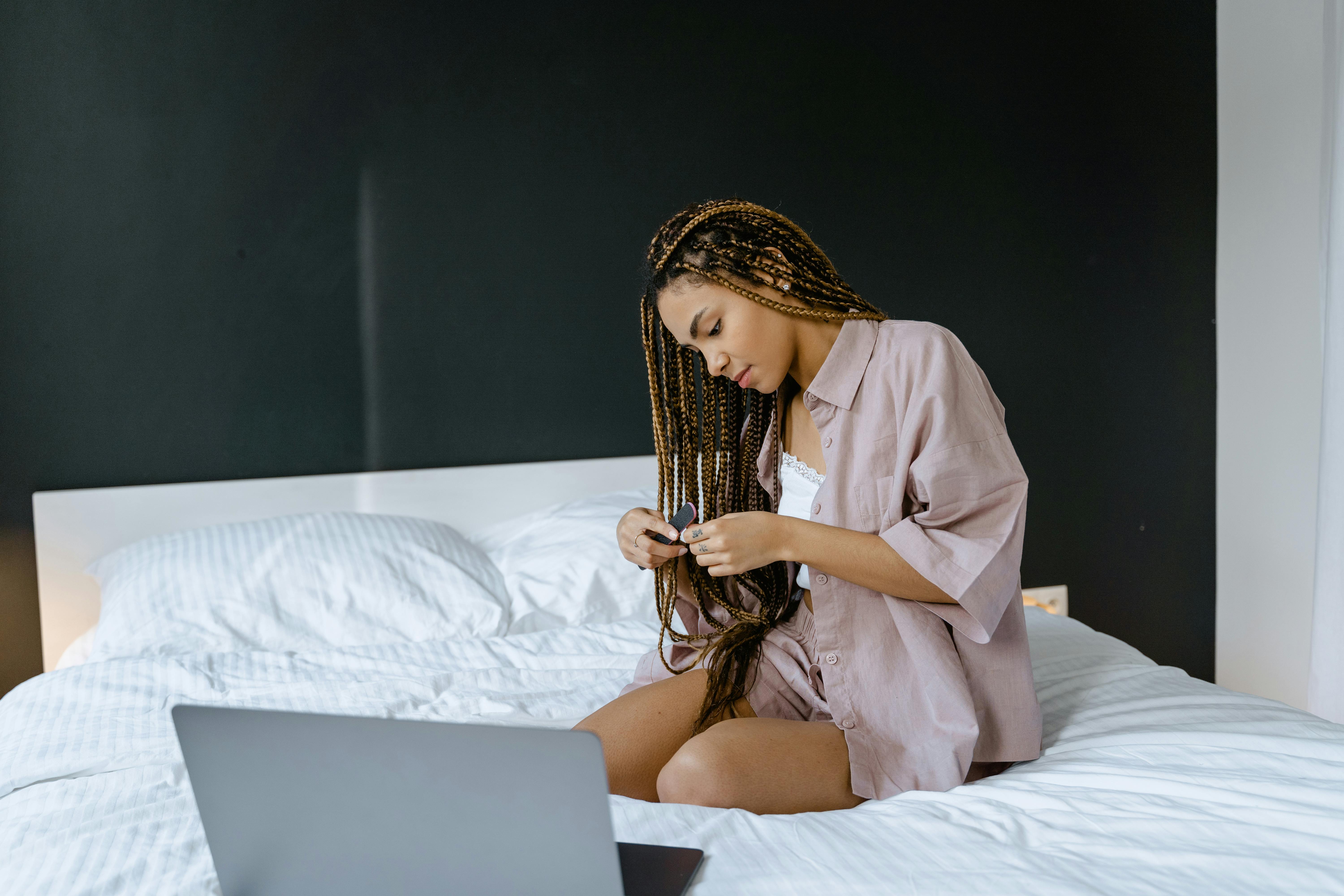 woman in brown robe sitting on bed