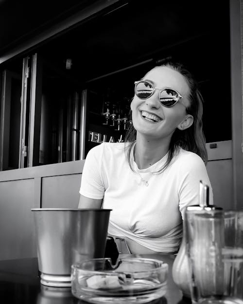 Free Monochrome Photo of Smiling Woman in White Crew Neck T-shirt Wearing Black Framed Eyeglasses Stock Photo