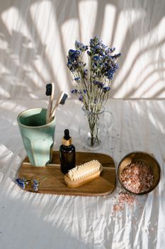 Elegant bath essentials with flowers in natural light setting, perfect for relaxation themes.