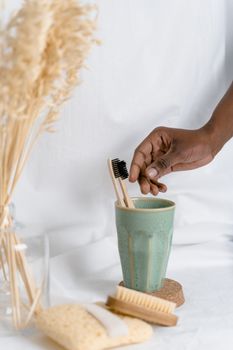Eco-friendly bathroom setup featuring bamboo toothbrush in ceramic cup with spa accessories.