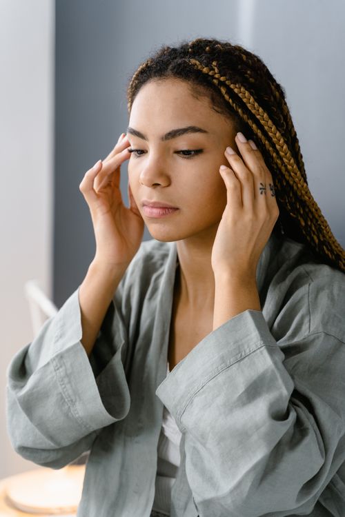 Free Woman applying facial care routine at home wearing comfortable robe. Stock Photo