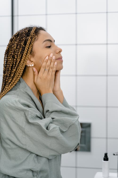 A Woman in Gray Robe Doing a Skin Care Routine