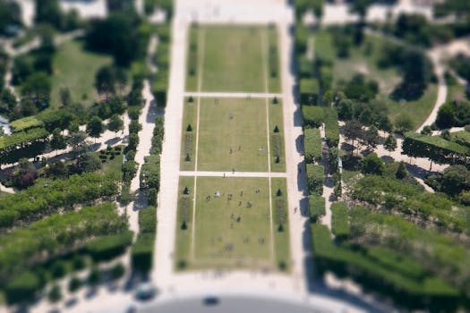 Tilt-shift aerial view of the lush Champ de Mars park in Paris, showcasing its iconic symmetrical layout.