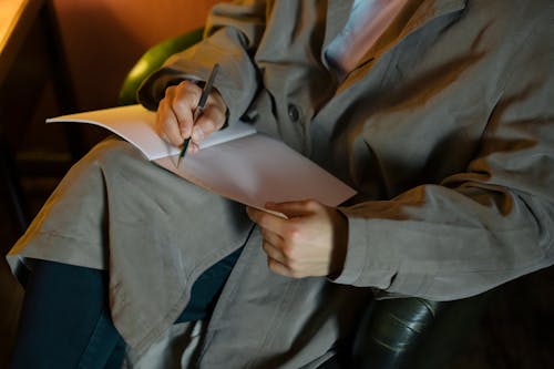 Man Writing on His Notebook