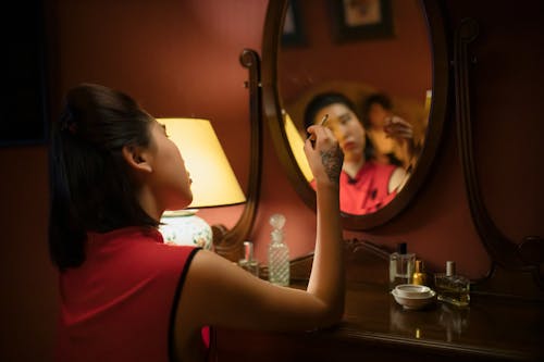 Woman in Red Dress Smoking in Front of the Mirror