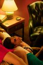 Man Sitting on the Floor Resting His Head on the Bed