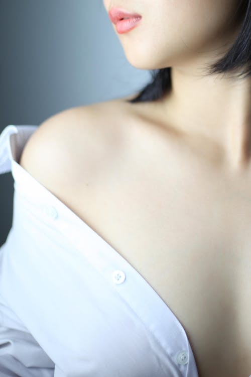 Alluring woman in white shirt with bare shoulder