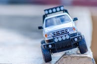 特写镜头展示了玩具越野车在户外岩石中航行的细节和动作