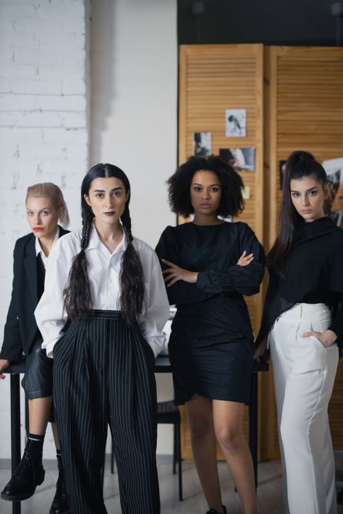 Free Group of professional women in stylish office attire posing confidently indoors. Stock Photo