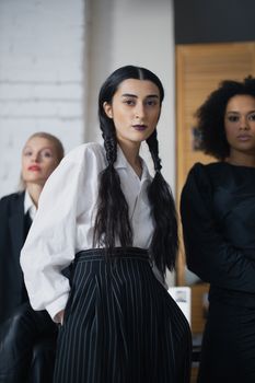 A group of diverse women in stylish business attire posing confidently indoors.