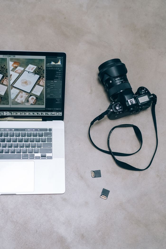 Creative flat lay of a laptop, camera and memory cards for photo and video editing