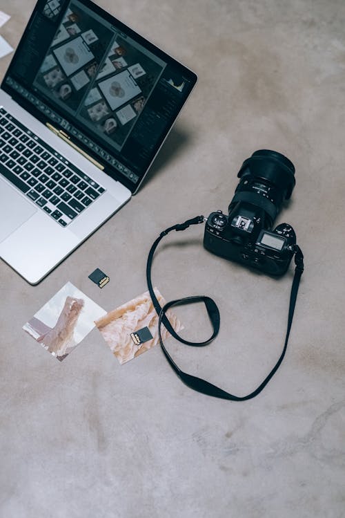 A Black Camera Beside a Laptop