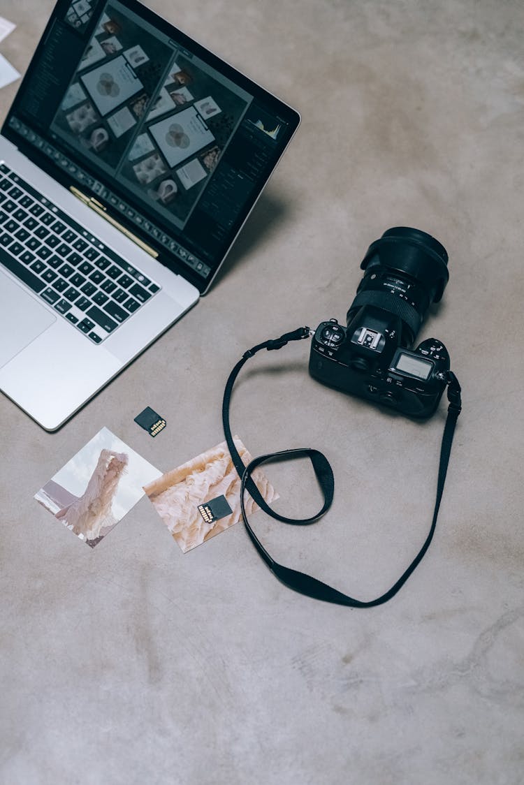 A Black Camera Beside A Laptop