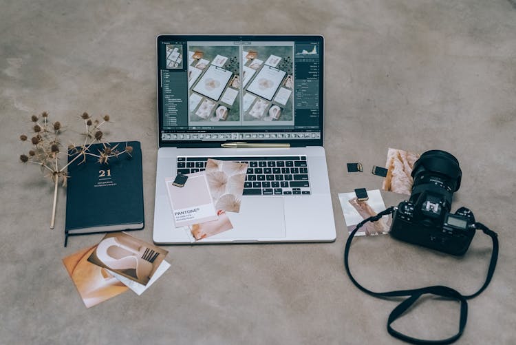 Laptop And Black Camera On A Flat Surface