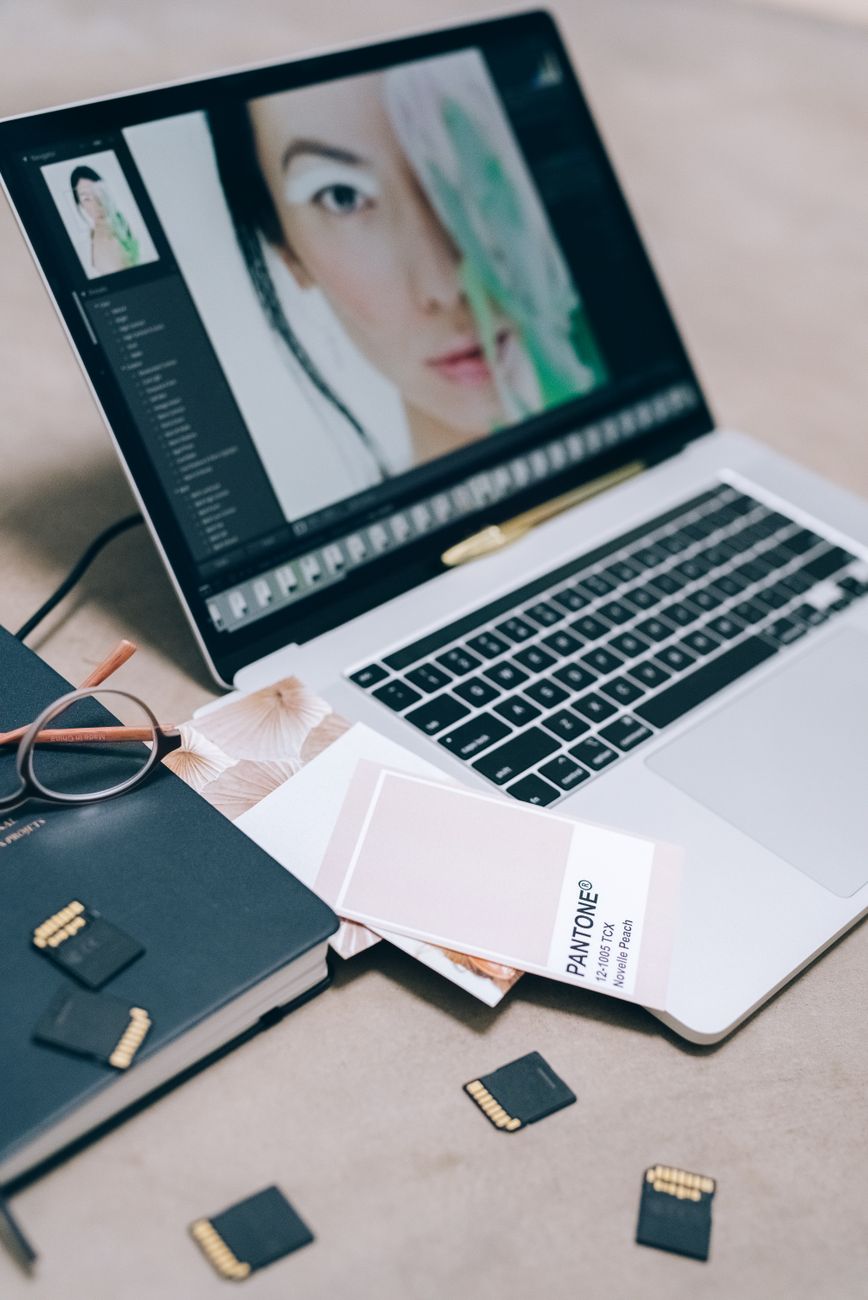 Laptop editing setup with colour guide and creative software on screen