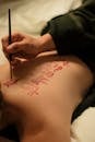 Person Writing on Woman's Back